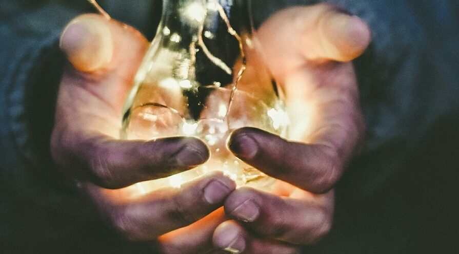 man holding incandescent bulb